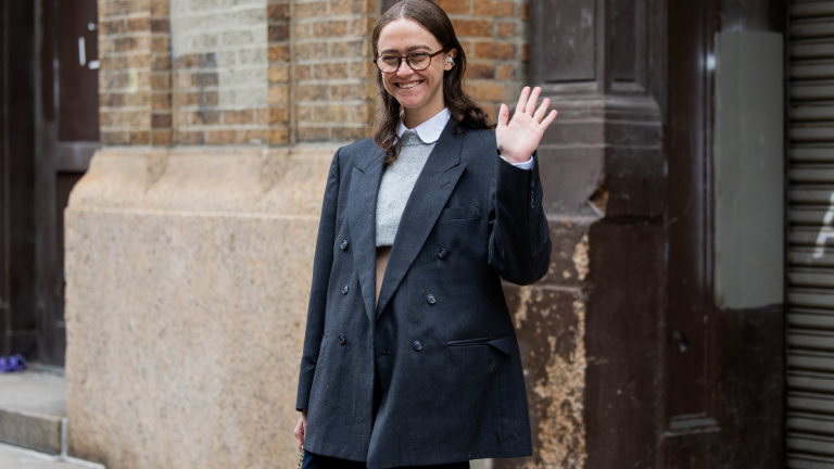 Ella Emhoff in cappotto grigio che saluta